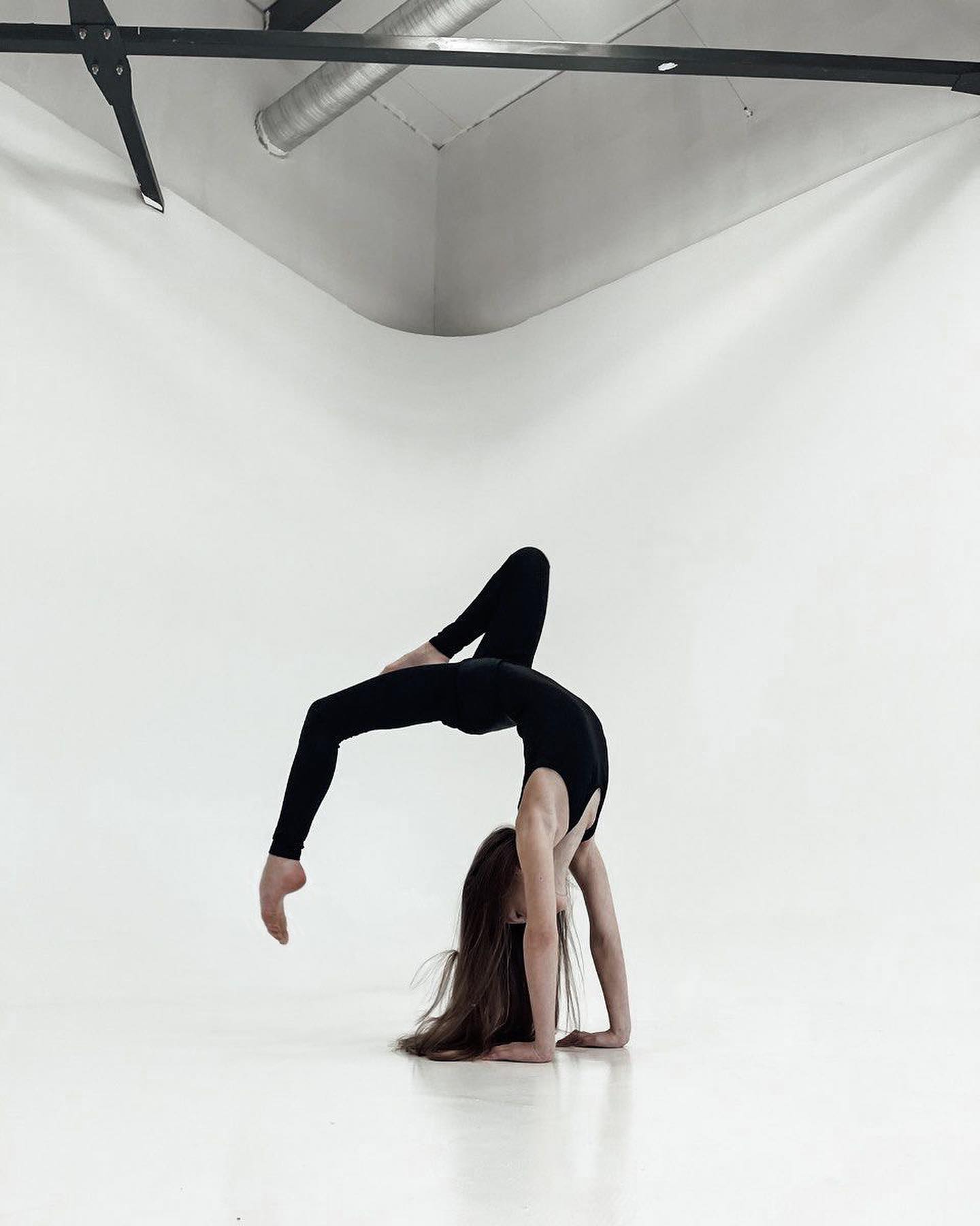 Model doing backbend in white studio